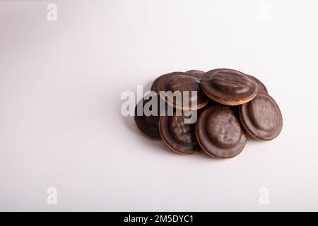 foto di un mucchio di biscotti rotondi ricoperti di cioccolato su sfondo bianco Foto Stock