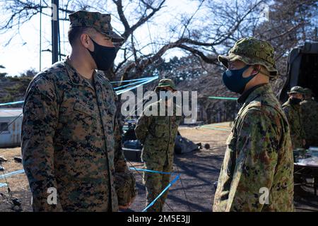 STATI UNITI Joshua Wilson, un valutatore di controller di attacco terminale congiunto con 5th Air Naval Gunfire Liaison Company (ANGLICO), 31st Marine Expeditionary Unit (MEU), discute le tattiche di supporto al fuoco con il sergente First Class Tomoya Tasaki, un capo di coordinamento del supporto al fuoco con il Regimental Landing Team 1st, Forza di autodifesa di terra giapponese (JGSDF) su campo Takighara, Prefettura di Shizuoka, Giappone, 6 marzo 2022. La collaborazione tra Marines e JGSDF con le stesse specialità professionali militari semplifica la comunicazione, consentendo tempi di risposta ed esecuzione più rapidi Foto Stock