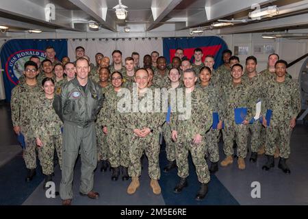 220307-N-DL524-1090 YOKOSUKA, Giappone (7 marzo 2022) i marinai posano per una foto con il capitano Fred Goldhammer, al centro, comandante ufficiale, il capitano Justin Issler, a sinistra, Ufficiale esecutivo, e il capo di comando Chris King dopo la promozione marinai durante una cerimonia Meritorious Advancement Program (MAP) nel precipietto degli Stati Uniti L’unica portaerei della Marina schierata a termine USS Ronald Reagan (CVN 76). LA MAPPA è un programma semestrale che permette agli ufficiali di comando di far avanzare i marinai nei gradi di retribuzione e-3 a e-5 al grado di retribuzione successivo. Ronald Reagan, il fiore all'occhiello del Carrier Strike Group 5, fornisce un Foto Stock