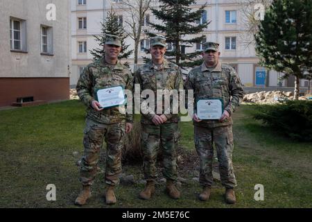 Da sinistra, Sgt. Major Robert S. Wilson, uscente 1st° Divisione Fanteria Forward Sergeant Major, col. Geoffrey A. Norman, vice comandante ufficiale – supporto della 1st° Divisione Fanteria, David M. Pelham, uscente 1st° Divisione Fanteria Forward Operations Sergente maggiore, posa per una foto dopo la cerimonia di premiazione tenutasi a Poznan, Polonia, 7 marzo 2022. La Meritorious Service Medal è assegnata a qualsiasi membro delle forze armate degli Stati Uniti che si distinguono per i risultati eccellenti o per il meritato servizio negli Stati Uniti. Foto Stock