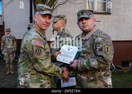 David M. Pelham, uscente 1st° Divisione Fanteria Forward Operations Sergente maggiore, si pone per una foto con il Major Gen. Douglas A. Sims II, comandante generale della 1st° Divisione Fanteria e Fort Riley dopo aver ricevuto la Meritorious Service Medal a Poznan, Polonia, 7 marzo 2022. La Meritorious Service Medal è assegnata a qualsiasi membro delle forze armate degli Stati Uniti che si distinguono per i risultati eccellenti o per il servizio meritorio. Foto Stock