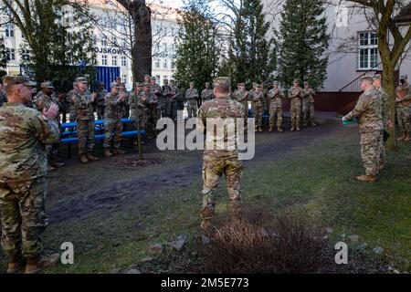 STATI UNITI I soldati dell'esercito assegnati alla 1st Divisione di Fanteria si congratulano con il maggiore Robert S. Wilson, uscente 1st Divisione di Fanteria Forward Sergeant Major, e il maggiore Sergeant Sgt. David M. Pelham, uscente 1st Divisione di Fanteria Forward Operations Sergeant Major, per aver ricevuto la Meritorious Service Medal a Poznan, Polonia, 7 marzo 2022. La Meritorious Service Medal è assegnata a qualsiasi membro delle forze armate degli Stati Uniti che si distinguono per i risultati eccellenti o per il servizio meritorio. Foto Stock