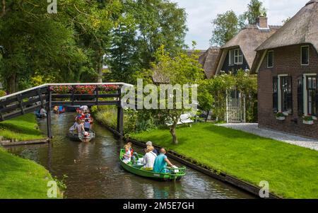 GIETHOORN, PAESI BASSI - AGOSTO 01 2017: Visitatori sconosciuti nel giro turistico in barca in un canale a Giethoorn. Le belle case e il giardinaggio Foto Stock