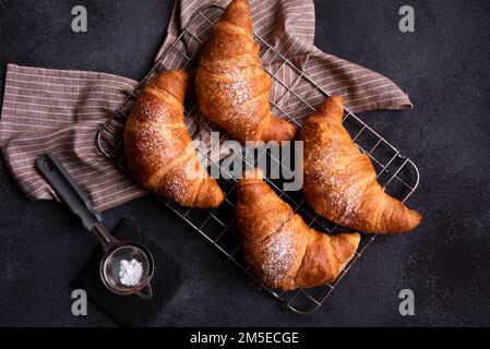 Deliziosi croissant appena sfornati su sfondo scuro Foto Stock