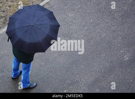 Kiev, Ucraina 9 dicembre 2018: Un uomo siede sul palco e guarda il telefono su uno sfondo nero Foto Stock