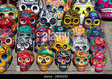 Teschi colorati in ceramica dipinti a mano che celebrano il giorno della festa dei morti in vendita per strada a Oaxaca, Messico. Foto Stock