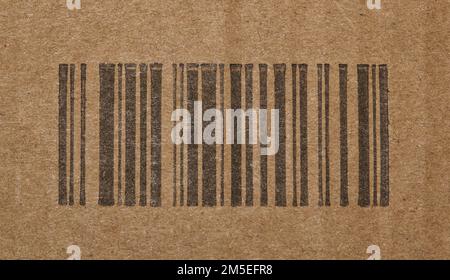 Codice a barre nero generico senza numeri su una scatola di cartone. Primo piano isolato con focalizzazione centrale sulle barre codificate di identificazione. Foto Stock
