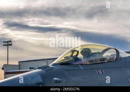 NEGLI STATI UNITI Air Force F-16 Fighter Pilot, assegnato alla 180th Fighter Wing della Guardia Nazionale dell'Ohio, attende di prendere un taxi in un F-16 Fighting Falcon, assegnato alla 180FW, per un volo di addestramento alla base militare Elmendorf-Richardson, Alaska, durante il Northern Command Exercise ARCTIC EDGE 2022, 7 marzo 2022. AE22 è un esercizio biennale di difesa della patria progettato per le forze armate statunitensi e canadesi per dimostrare ed esercitare una capacità congiunta di dispiegarsi e operare rapidamente nell'Artico. Foto Stock