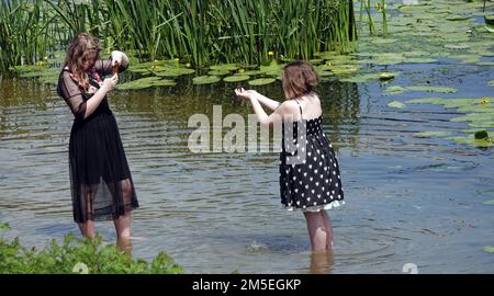 Kiev, Ucraina 12 luglio 2020: Due ragazze vengono fotografate al telefono mentre si trovano in acqua sulla riva Foto Stock