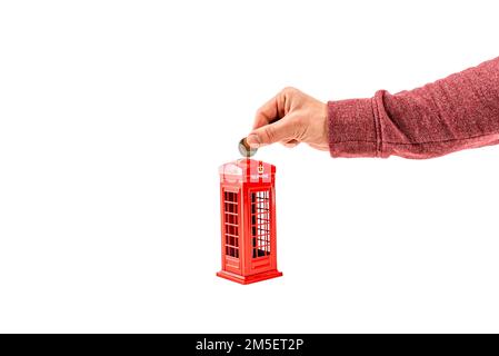 Primo piano uomo mettere soldi in una moneybox, penny o piggy banca. Denaro risparmio moneta in euro per l'assistenza sanitaria, la casa nuova, il futuro, la scuola, il college. Foto Stock