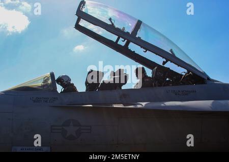 MARE DELLE FILIPPINE (10 marzo 2022) il Lt. Colby Diamond, di Parker, Colón, e il Capt. Lewis Callaway, di Houston, entrano in un EA-18G Growler, assegnato ai 'Wizards' di Electronic Attack Squadron (VAQ) 133, sul ponte di volo della portaerei di classe Nimitz USS Abraham Lincoln (CVN 72). Abraham Lincoln Strike Group è in fase di implementazione pianificata nell'area delle operazioni della flotta 7th degli Stati Uniti per migliorare l'interoperabilità attraverso alleanze e partnership e al tempo stesso fungere da forza di risposta pronta a sostegno di una regione indomPacifico libera e aperta. Foto Stock