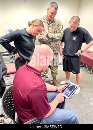 Nella foto da sinistra: SPC. Madeleine Bryan, 1st Lt. Steven Candito e CPT. Will Holcomb guarda come il maggiore Anthony Williams, capo, Bayne-Jones Army Community Hospital Rehabilitation Department conduce una valutazione della meccanica del salto di Bryan utilizzando un'app di terapia fisica durante l'esame muscoloscheletrico, l'intervento e la formazione di rinvio del 8 e 9 marzo presso il Joint Readiness Training Center e Fort Polk, Louisiana. Foto Stock