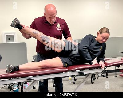 Anthony Williams, capo, Bayne-Jones Army Community Hospital Rehabilitation Department dimostra una tecnica per testare la forza di flessione delle gambe e dell'anca con SPC. Madeleine Bryan, Combat Medic, 1st battaglione, 509th reggimento di fanteria, durante l'esame muscoloscheletrico, Intervento e formazione di rinvio 8 e 9 marzo presso il Joint Readiness Training Center e Fort Polk, Louisiana. Foto Stock