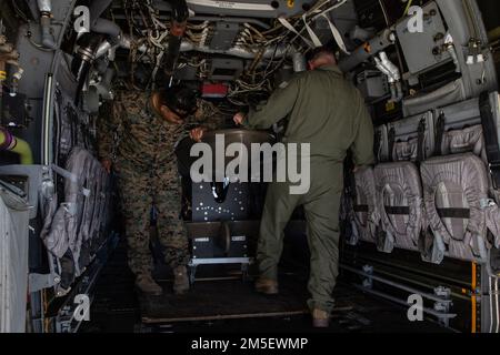 STATI UNITI Marines Corps Master Sgt. Ernest Rivera, a destra, un responsabile della sicurezza da 1st Battaglione di supporto all'atterraggio, 1st Marine Logistics Group, 1st Marine Expeditionary Force, Charles Bishop, capo dell'equipaggio con Marine Medium Tiltrotor Squadron 364, Marine Aircraft Group 39, 3rd Marine Aircraft Wing, osserva il carico del Wave Glider in un'Osprey MV-22B presso Marine Corps Air Station Camp Pendleton, California, 9 marzo 2022. Il Wave Glider è un veicolo di superficie senza equipaggio con sensori autonomi persistenti che ricevono e inviano dati fornendo una maggiore dominanza marittima a supporto di Foto Stock