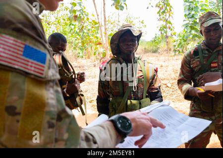 NEGLI STATI UNITI Esercito Verde Beret assegnato a 3rd Special Forces Group (Airborne) discute dettagli di un ordine operativo (OPORD) con i soldati Beninesi durante un esercizio di addestramento sul campo in Benin, Africa, 09 marzo 2022. L’impegno internazionale è necessario per contrastare l’estremismo violento, e i nostri impegni militari sono solo uno dei modi in cui sosteniamo i partner africani come parte di una comunità internazionale. Foto Stock