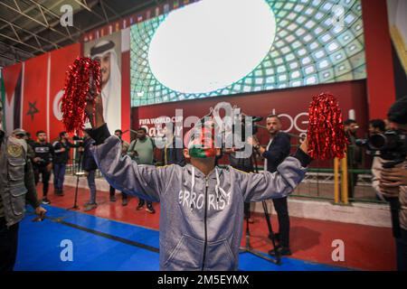 Gli appassionati di calcio palestinesi alzano le bandiere nazionali e marocchine mentre celebrano la vittoria del Marocco nella partita di calcio del Qatar 2022 della Coppa del mondo 16 contro il Portogallo nella città di Gaza. Palestina. Foto Stock