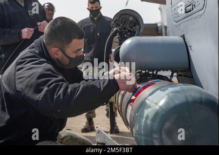 YOKOSUKA, Giappone (10 marzo 2022) Aviation Ordnanceman 1st Class Juan Alvarez, di Miami, assicura un MK 54 leggero Torpedo ad un MH-60R Sea Hawk, attaccato ai “Saberhawks” di Helicopter Maritime Strike Squadron (HSM) 77, durante un esercizio di addestramento al Comandante, Fleet Activities Yokosuka. Il modello MK 54 è un siluro inerte da training progettato per essere recuperato e riutilizzato per gli esercizi di training. HSM-77 è attaccato al comandante, Task Force 70 e schierato in avanti nella zona di responsabilità della flotta degli Stati Uniti 7th a sostegno di un libero e aperto Indo-Pacific. Foto Stock