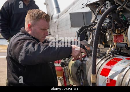 YOKOSUKA, Giappone (10 marzo 2022) Capo Aviazione Ordnanceman Spencer Holman, da Seattle, ottiene un MK 54 leggero Torpedo ad un MH-60R Sea Hawk, attaccato ai “Saberhawks” di Helicopter Maritime Strike Squadron (HSM) 77, durante un esercizio di addestramento al Comandante, Fleet Activities Yokosuka. Il modello MK 54 è un siluro inerte da training progettato per essere recuperato e riutilizzato per gli esercizi di training. HSM-77 è attaccato al comandante, Task Force 70 e schierato in avanti nella zona di responsabilità della flotta degli Stati Uniti 7th a sostegno di un libero e aperto Indo-Pacific. Foto Stock