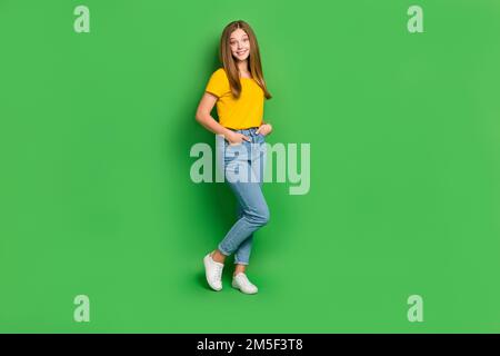 Foto a dimensione intera di felice giovane felice felice felice sorriso toothy posa isolato su sfondo di colore verde Foto Stock