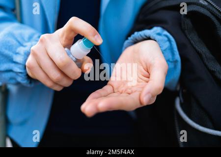Un primo piano delle mani di una donna utilizzando un disinfettante per le mani - il concetto di una pandemia Foto Stock