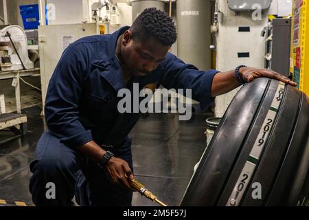 PHILIPPINE SEA (11 marzo 2022) Aviation Structural Mechanic Airman Everette Isom, di Rock Hill, S.C., controlla la pressione dell'aria su un pneumatico a bordo della portaerei di classe Nimitz USS Abraham Lincoln (CVN 72). Abraham Lincoln Strike Group è in fase di implementazione pianificata nell'area delle operazioni della flotta 7th degli Stati Uniti per migliorare l'interoperabilità attraverso alleanze e partnership e al tempo stesso fungere da forza di risposta pronta a sostegno di una regione indomPacifico libera e aperta. Foto Stock