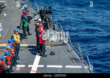 MARE DELLE FILIPPINE (10 marzo 2022) i marinai si preparano a sparare le linee al comando militare Sealift carico secco e nave munizioni USNS Alan Shepard (T-AKE 3) durante un rifornimento in mare a bordo del cacciatorpediniere missilistico guidato di classe Arleigh Burke USS Spruance (DDG 111). Abraham Lincoln Strike Group è in fase di implementazione pianificata nell'area delle operazioni della flotta 7th degli Stati Uniti per migliorare l'interoperabilità attraverso alleanze e partnership e al tempo stesso fungere da forza di risposta pronta a sostegno di una regione indomPacifico libera e aperta. Foto Stock