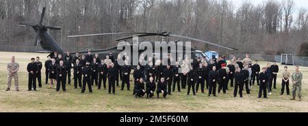 I cadetti della Marina JROTC posano per una foto di gruppo di fronte a un falco nero UH-60 durante una visita della Guardia nazionale dell'esercito del Maryland alla loro scuola alla Huntingtown High School di Huntingtown, Maryland, il 10 marzo 2022. I cadetti hanno anche appreso le varie specialità professionali militari e le esperienze personali dei soldati nel MDARNG. Foto Stock