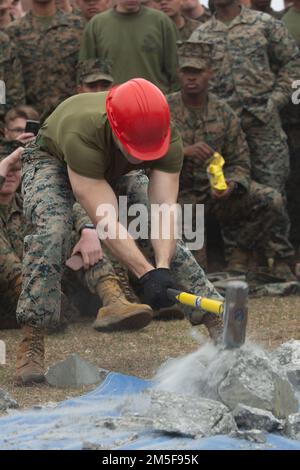 STATI UNITI Joshua Pratt, un ingegnere di combattimento con 2D Combat Engineer Battalion, 2D Marine Division, rompe un blocco di cemento durante la sfida Find the Rebar a Ellis Field sulla base dei Marine Corps Camp Lejeune, North Carolina, 10 marzo 2022. La Marine Corps Engineer School ha ospitato la St. Patrick's Day Field si riunisce per gli ingegneri di tutto il corpo dei Marine Installations East per aumentare il morale e partecipare a una competizione amichevole. Foto Stock