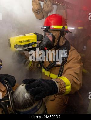 220310-N-HG846-1075 IONIAN SEA (10 marzo 2022) – Information System Technician 3rd Class Conor Nichols, di Texarkana, Texas, utilizza una termocamera Naval Firefighter durante un'esercitazione antincendio a bordo di un cacciatorpediniere a missile guidato di classe Arleigh Burke USS Mitscher (DDG 57), 10 marzo 2022. Mitscher è attualmente schierato con il gruppo di carrier Strike di Harry S. Truman negli Stati Uniti Sesta area di attività Fleet a sostegno degli interessi degli Stati Uniti, alleati e partner in Europa e Africa. Foto Stock