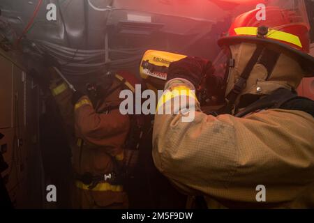 220310-N-HG846-1063 IONIAN SEA (10 marzo 2022) – i marinai effettuano la revisione di un incendio simulato con un rake e una termocamera Navale durante una trivella antincendio a bordo di un cacciatorpediniere missilistico guidato di classe Arleigh Burke USS Mitscher (DDG 57), 10 marzo 2022. Mitscher è attualmente schierato con il gruppo di carrier Strike di Harry S. Truman negli Stati Uniti Sesta area di attività Fleet a sostegno degli interessi degli Stati Uniti, alleati e partner in Europa e Africa. Foto Stock