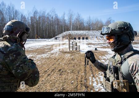 Un SOF lituano Jaeger si prepara a far tempo a un membro SOF del 10th Special Forces Group su una serie vicino Kaunas, Lituania 12 marzo 2022. Queste valutazioni congiunte della gamma giornaliera sono utilizzate per scambiare tattiche, migliorare la preparazione alle missioni e mantenere avanzate abilità di marketing di combattimento, promuovendo al contempo una forte collaborazione con le forze alleate. Foto Stock
