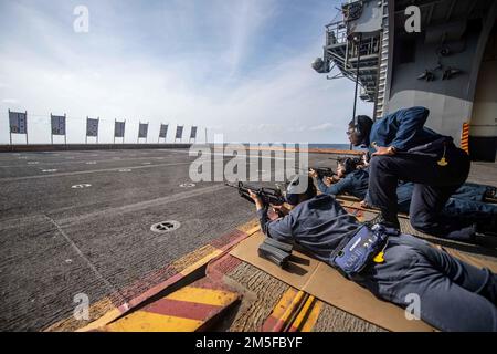 OCEANO PACIFICO (11 marzo 2022) Aviazione Ordnanceman Airman Principe Boakye, a destra, da Atlanta, assegnato alla nave d'assalto anfibio a dispiegamento diretto USS America (LHA 6), Coach Logistics Specialist 3rd Classe Patrick Belocura, da Bacolod, Filippine, assegnato anche all'America, Durante un esercizio di fuoco vivo con un fucile del M4 su uno degli ascensori della nave. L'America, nave guida dell'America Amphibious Ready Group, insieme alla Marine Expeditionary Unit 31st, opera nell'area di responsabilità della flotta statunitense 7th per migliorare l'interoperabilità con alleati e partner e fungere da pronta r Foto Stock