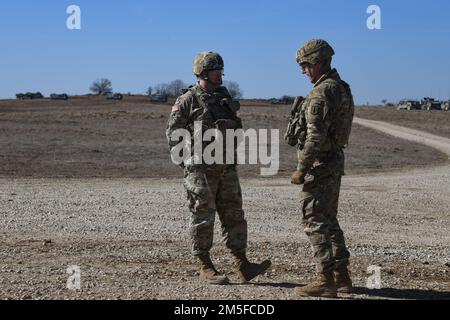 STATI UNITI Daniel Miller, a sinistra, comandante di 41st Brigata artiglieria di campo (41st fa BDE), parla con il Lt. David Henderson, comandante di 1st 7th Battaglione, 6th Field Artillery Regiment, 41st fa BDE, prima di un'esercitazione di fuoco dal vivo presso la Grafenwoehr Training Area, Germania, 11 marzo 2022. Il dispiegamento delle forze statunitensi in questo caso è una misura prudente che sostiene gli obiettivi collettivi di prevenzione della guerra della NATO, l’orientamento difensivo e l’impegno a proteggere tutti gli alleati. Foto Stock