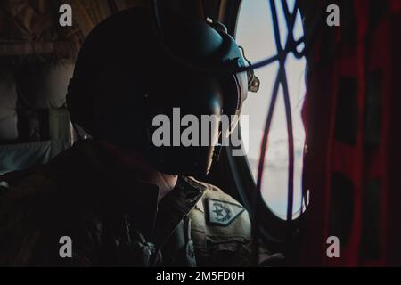 Un Nevada Army National Guard Bravo Company, 1/189th l'ingegnere di volo dell'aviazione guarda fuori una finestra durante un volo di incentivazione sul nord del Nevada, 11 marzo 2022. Oltre 20 Airmen provenienti da circa 152nd Airlift Wing hanno volato in elicottero con membri del team dirigenziale senior come l'Adjutant Generale per lo Stato del Nevada e il comandante capo dello stato Sergente. Foto Stock