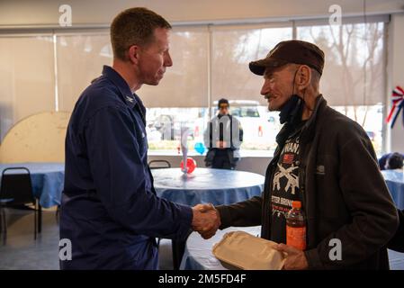Il capitano Jason Smith, comandante del settore della Guardia Costiera Houston-Galveston, scuote le mani con un veterano dopo aver pranzato con lui durante un evento di volontariato della Combined Federal Campaign nella casa di un veterano di Houston a Houston, Texas, il 11 marzo 2022. I membri hanno cucinato e tagliato il pranzo ai residenti locali accanto agli Stati Uniti L'immigrazione e l'applicazione delle dogane e il Michael E. DeBakey Veterans Affairs Medical Center, come parte di un evento volontario in collaborazione con gli Stati Uniti Vets Houston e la Veteran Initiative. Foto Stock
