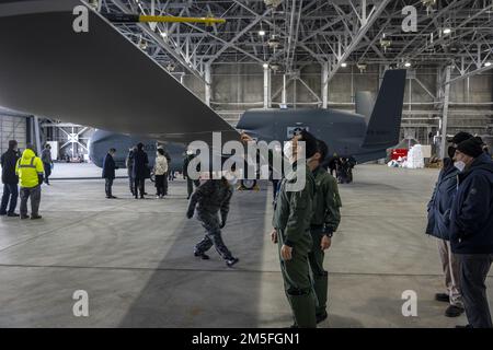 Il personale della forza di autodifesa aerea giapponese guarda un falco globale RQ-4B in un hangar della base aerea di Misawa, Giappone, 12 marzo 2022. Il modello RQ-4B è un aeromobile pilotato in remoto ad alta quota, lunga durata e con una suite di sensori integrati che offre funzionalità globali per tutte le condizioni atmosferiche, di intelligence diurna o notturna, sorveglianza e ricognizione. L'aggiunta di questo aeromobile all'inventario della Japan Air Self-Defense Force sostiene direttamente la difesa del Giappone e la pace e la stabilità nella regione dell'Indo-Pacifico. Foto Stock