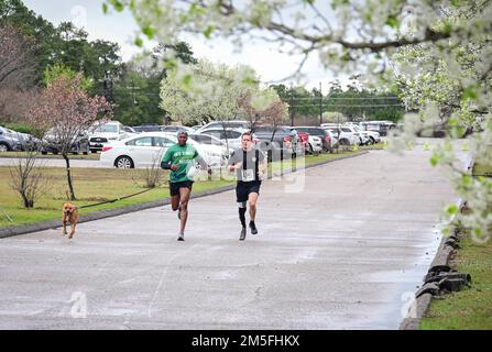 Comando posta Sgt. Maig. Philson Tavernier, a sinistra, e il col. Kent Solheim, 165th comandante della Brigata della Fanteria, attraversare il traguardo del St PATS 5K corrono e camminano 12 marzo 2022. A guidare per loro è stato il cane Zoey di Tavernier. Foto Stock