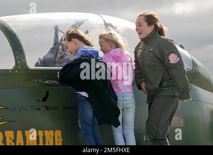 STATI UNITI Air Force 1st Lt Christana Wagner, 89th Flying Training Squadron T-6 il pilota istruttore Texan II della Sheppard Air Force base, Texas, sorride mentre parla con due bambini dell'aeromobile T-6 Texan II, 12 marzo 2022, alla Moody Air Force base, Georgia. La Youth Open House ha culminato la settimana delle Donne nell'aviazione ed è stata finalizzata a collegare una generazione più giovane ad Airmen e a ispirarli per le carriere in airpower che conducono ad un'aeronautica più diversificata ed efficace nel futuro. Foto Stock