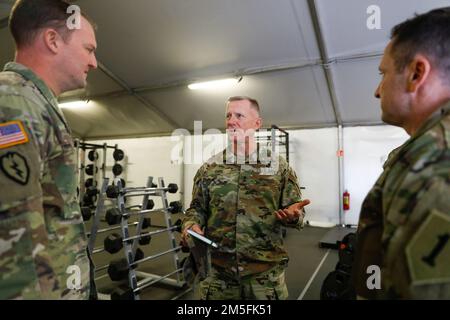 STATI UNITI Douglas Sims, comandante generale della 1st° divisione fanteria parla con gli Stati Uniti Il maggiore dell'esercito Jonathan Macrae, partito, 1st squadra di combattimento della Brigata blindata, 1ID ufficiale esecutivo e il comando Sgt. Il maggiore Christopher Shaiko, sergente di comando del 1ABCT, 1ID a Zagan, Polonia, 13 marzo 2022. Sims visitò Zagan, controllando gli impianti, fu aggiornato sulle operazioni e presentò monete ai soldati in sospeso. Foto Stock