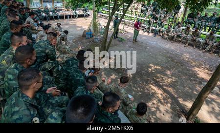 I membri dell'Esercito reale Tailandese e del Battaglione ingegnere della Brigata 29th, 3rd squadra di combattimento della Brigata, 25th divisione fanteria, ascoltano un istruttore che descrive diversi tipi di vegetazione e i loro usi durante un corso di sopravvivenza nella giungla, il 13 marzo 2022, Fort Thanarat, Thailandia. La sopravvivenza nella giungla è un'area in cui i soldati statunitensi stazionati alle Hawaii e le forze dell'Esercito tailandese reale si sono riunite per condividere le pratiche per prepararsi meglio a vicenda per operazioni future. Foto Stock