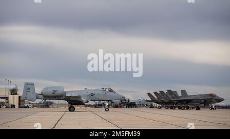 Un A-10 Thunderbolt II, della 124th Fighter Wing, si siede e attende di prendere un taxi vicino a F-35B Lightning IIS, dagli Stati Uniti Marine Corps Marine Operational Test and Evaluation Squadron One (VMX-1), presso Gowen Field, Boise, Idaho, marzo 13, 2022. I due aeromobili si stavano formando insieme per migliorare le operazioni di volo congiunte. Foto Stock