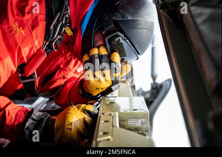 NEGLI STATI UNITI Air Force Airman, assegnato a 212th Rescue Squadron, osserva la zona di atterraggio dalla HC-130J Hercules, assegnato al 211th Rescue Squadron, durante l'esercizio ARTICO BORDO 2022 sul Nord Alaska, 14 marzo 2022. AE22 è un esercizio biennale di difesa per gli Stati Uniti Il comando del Nord e le forze armate canadesi per dimostrare ed esercitare una capacità congiunta di dispiegarsi e operare rapidamente nell'Artico. Foto Stock