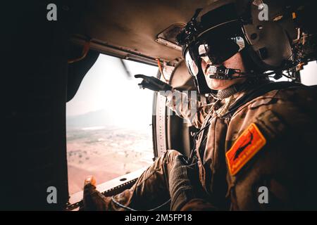 Un capo dell'equipaggio di elicotteri UH-60 Black Hawk, assegnato a 2nd battaglione, 25th Brigata dell'Aviazione di combattimento, indica diversi punti di riferimento noti come parte di una missione aerea durante Hanuman Guardian 22, Lop Buri, Regno di Thailandia, 15 marzo 2022. Lavorando insieme, gli Stati Uniti L'esercito e l'esercito tailandese reale conducono eventi multinazionali e combinati di task force che sono vitali per mantenere la prontezza e l'interoperabilità delle forze di sicurezza in tutta la regione. Foto Stock