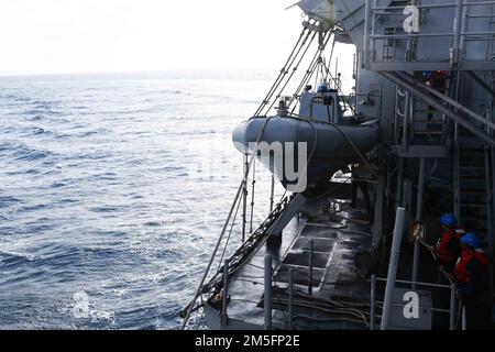 MARE DELLA CINA ORIENTALE (14 marzo 2022) i marinai preparano una barca gonfiabile a scafo rigido (RHIB) a bordo dell'incrociatore missilistico guidato della classe Ticonderoga USS Mobile Bay (CG 53). Abraham Lincoln Strike Group è in fase di implementazione pianificata nell'area delle operazioni della flotta 7th degli Stati Uniti per migliorare l'interoperabilità attraverso alleanze e partnership e al tempo stesso fungere da forza di risposta pronta a sostegno di una regione indomPacifico libera e aperta. Foto Stock