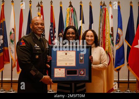 Razell Perry (al centro), moglie del comando Sgt. Major Perry III, viene presentata una targa di addio del Major Gen. Michel M. Russell Sr. (A sinistra), comandante generale, 1st Theater Sustainment Command, e sua moglie, Sieglinde (a destra), durante una cerimonia di rinuncia alla responsabilità a Fort Knox, Kentucky, 15 marzo 2022. Perry assumerà la carica di consulente senior arruolato del Vice Capo di Stato maggiore dell’esercito per le installazioni, chiamato anche Vice Capo di Stato maggiore, G-9. Foto Stock