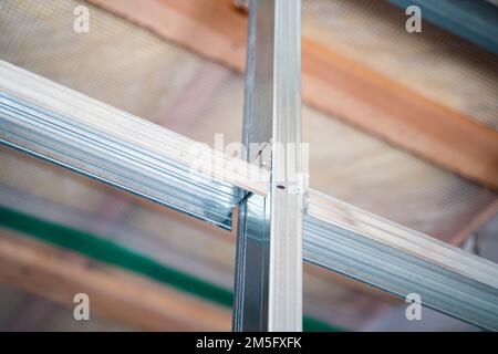 Nervature di irrigidimento in un profilato metallico in un primo piano di parete in cartongesso. Costruire un muro in una casa privata Foto Stock