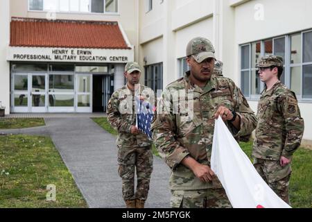 Gli aerei assegnati alla 18th Wing prendono parte a un dettaglio della bandiera Retreat presso la Kadena Air base, Giappone, 15 marzo 2022. Una volta che il ritiro ha inizio alla base aerea di Kadena, è seguito da “Kimi GA Yo”, l'inno nazionale giapponese e gli Stati Uniti Inno nazionale. Foto Stock