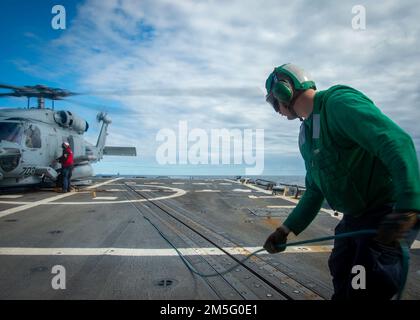 220315-N-FS190-1178 OCEANO ATLANTICO (15 marzo 2022) Aviation Machinist’s Mate 2nd Class Benjamin Gordon lancia un cavo di comunicazione da un elicottero MH-60R Sea Hawk, collegato ai “Grandmasters” dell’elicottero Maritime Strike Squadron (HSM) 46, sul ponte di volo del cacciatorpediniere guidato-missile Arleigh Burke USS Truxtun (DG 103) Per l'esercizio della Task Force (TFEX), 15 marzo 2022. TFEX è un esercizio basato su scenari che serve da certificazione per l'implementazione indipendente di navi ed è designato a testare la preparazione e le prestazioni della missione in operazioni integrate. Truxtun è in corso per Carr Foto Stock