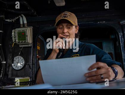 GOLFO ARABICO (16 marzo 2022) CMdR. Meghan Bodnar, ufficiale comandante, si rivolge all'equipaggio su un sistema intercom durante una cerimonia di premiazione del Guerriero della settimana a bordo del cacciatorpediniere missilistico guidato USS Gridley (DDG 101) nel Golfo Arabico, marzo 16. Gridley è schierato nell'area delle operazioni della flotta degli Stati Uniti 5th a sostegno delle operazioni navali per assicurare la stabilità e la sicurezza marittima nella regione centrale, collegando il Mediterraneo e il Pacifico attraverso l'Oceano Indiano occidentale e tre punti di arresto strategici. Foto Stock