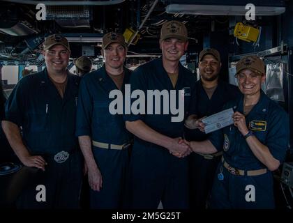 GOLFO ARABICO (16 marzo 2022) Information Systems Technician Seaman Jacob Roof, al centro, si pone per un quadro con CMdR. Meghan Bodnar, destro, ufficiale comandante, e vari altri capi di dipartimento durante una cerimonia di premiazione Warrior of the Week a bordo del cacciatorpediniere missilistico guidato USS Gridley (DDG 101) nel Golfo Arabico, marzo 16. Gridley è schierato nell'area delle operazioni della flotta degli Stati Uniti 5th a sostegno delle operazioni navali per assicurare la stabilità e la sicurezza marittima nella regione centrale, collegando il Mediterraneo e il Pacifico attraverso l'Oceano Indiano occidentale e tre punti di arresto strategici. Foto Stock